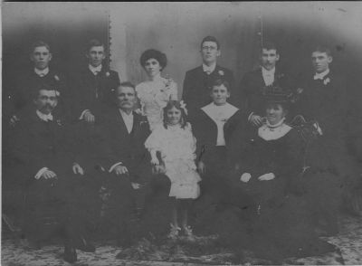 1909 - Richard and Bridget (nee Carrucan) Lane with family on the occasion of daughter Bridget's wedding
Bridget CARRUCAN (1858-1949) married Patrick Richard LANE (1851-1926) in 1875. Amongst their children were Michael (1876), John J (1877), Mary (1879-1900), Susan (1882-1892) Bridget (Dolly) (1883), Ellen (Nell) (1887-1904), Thomas Phillip (Tom) (1893) and Timothy Anthony Silvester (Syl) (1896). This photo is taken on the day of Dolly's wedding in 1908 or 1909 to John McMahon. At that time, three of the daughters, Susan, Mary and Ellen have already died. Photo shows

Back L-R: Thomas Phillip (Tom), Patrick Francis (Pat), Bridget (Dolly), Richard Donal (Dick), John (Jack), Cornelius Joseph (Con)
Front L-R: Michael (Mick), Patrick (Father), Eileen Mary (Eileen), Timothy Anthony Silvester (Syl), Bridget Lane (nee Carrucan)
