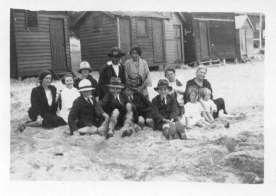 1925 - Carrucan Family at Black Rock
Holidays or excursions of even a day were few and far between for the Carrucan family of Eltham but the following photo shows one such occasion, at Black Rock visiting the Ryans. Pat, Ken and Jack Carrucan are in suits and hats in the front. Betty Carrucan is in the white dress second from left.. Mary Carrucan (nee Sweeney) is the lady kneeling back right. On the far left is Nellie Murray, the sister of Jim Murray who was the last of the old Eltham relatives to die.
