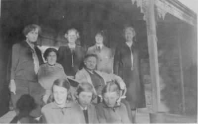1926 approx - Carrucan photo at Dalton St - Betty in front
On the front porch at the Dalton St Eltham farmhouse circa 1926. Mary Carrucan (nee Sweeney) is second from left with her eyes partially closed andher daughter Betty is in the front middle. Ellen (Nana) Sweeney is on the left, then Mary, then Nellie Oliver, then an unidentified schoolgirl, then Nessie (Ellen) Sweeney. We cannot think who the lady in the cane chair might be. It seems possible she is one of the relations on the Carrucan side.
