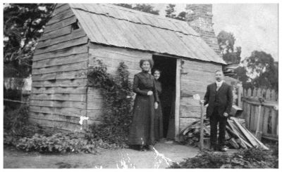 1915 circa - Culla Hill original hut - Ellen and Kathleen Sweeney and Michael Carrucan
Nana (Ellen Sweeney) and Cassie (Kathleen Sweeney) proudly pose in front of this humble structure, the first hut built by Thomas Sweeney, possibly as early as 1843. John Francis Sweeney was probably born therein.
Mick Carrucan (who married Mary Sweeney in 1910) is also in the picture.
This photo was no doubt taken by Joseph Rance Douie during a weekend visit to Eltham somewhere around the 1910 period or slightly later.
