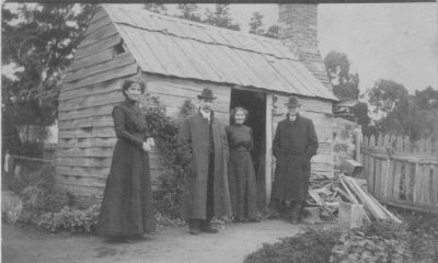 1915 approx - Culla Hill original hut - Ellen (Nana) and Kathleen (Cassie) Sweeney with Michael and Frank Carrucan
Nana (Ellen Sweeney) and Cassie (Kathleen Sweeney) proudly pose in front of this humble structure, the first hut built by Thomas Sweeney, possibly as early as 1843. John Francis Sweeney was probably born therein.
The two other figures are Mick Carrucan (who married Mary Sweeney in 1910) and Frank Carrucan, his cousin (who married Kas Sweeney in 1915). We surmise that Frank is either visiting Eltham prior to marrying Kas in December 1915 or they are already married.
It is one of a pair"
