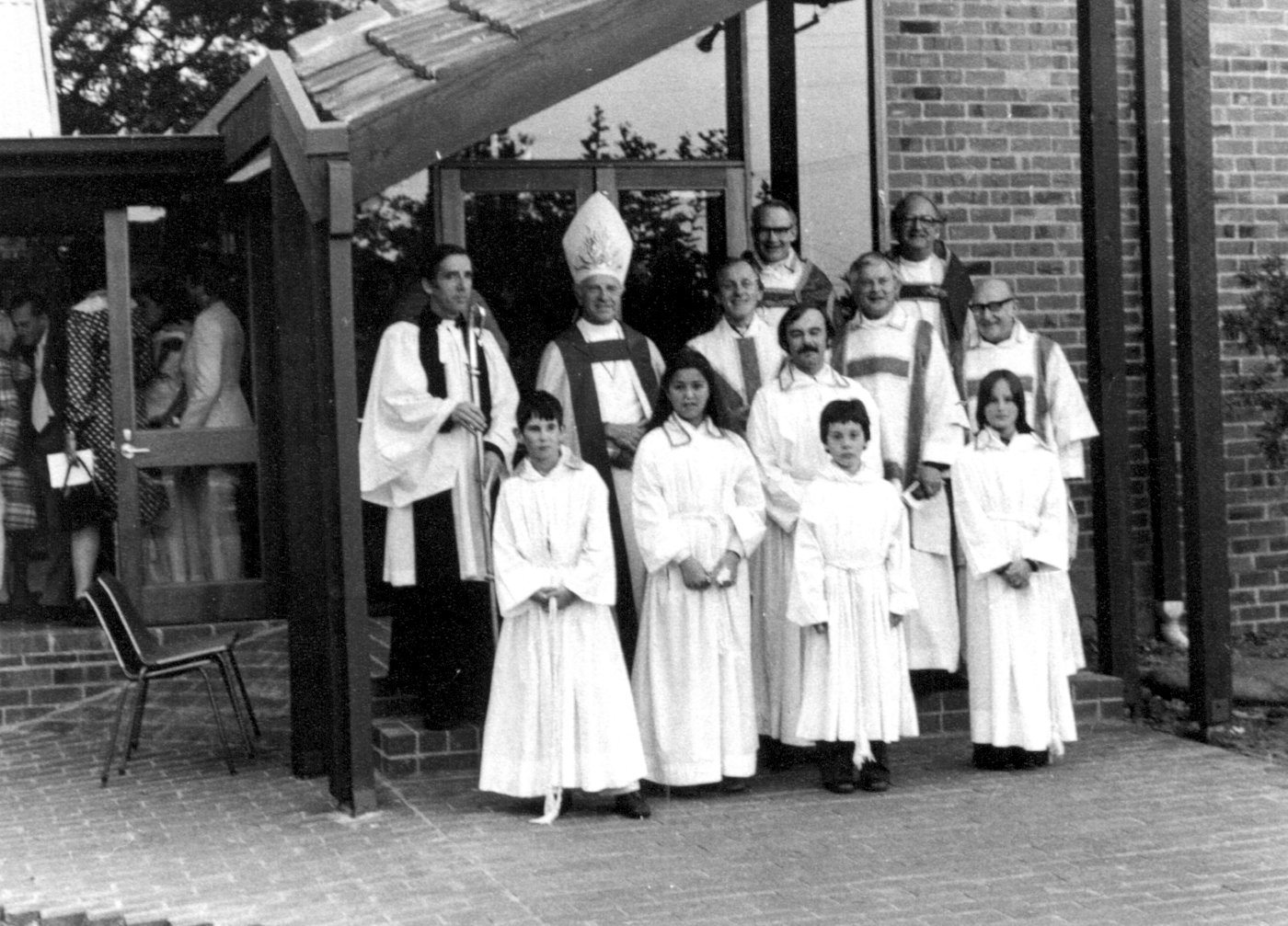 1978-11-5 Re-dedication
For years the unfinished wall of the church had been a source of embarrassment and was a physical reminder of the neglect of the parish over the years.  It also worked against the establishment of a solid foundation for ministry. In 1977, following the success of the planned giving programme, the Vestry decided, with the support of Bishop James Grant, that the building should be completed. Mr Vanne Trompf, a creative architect who had successfully carried out some work to Anglican churches, came up with a wonderful solution to replace the temporary wooden eastern wall with a new glass window. The renovation also included a new vestry and church entrance and required the altar to be moved from the eastern end to the western end of the church. The building work was completed and was blessed by Archbishop Robert Dann in a Re-dedication Ceremony on 5th November 1978.  A morning prayer service was held at 8:00 AM, followed by a prayer vigil which lasted until the re-dedication ceremony commenced at 4:00 PM.
