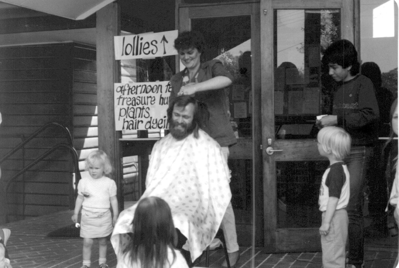 1980s mid - Alan Cadwallader a haircut for a good cause
Rev Alan Cadwallader who had been at Holy Trinity Kensington, took over the Parish in late 1982.  Fr Alan was married and the parish, after some time, once again had a family at St Linus’ House.  Alan and Robin’s family of two children increased to four during their five years at St Linus’.  This was a time of much creativity and spiritual growth.  Outreach to the community increased as Alan’s spirit of inclusiveness found an expression in events such as the annual parish camp, attended by parishioners of all age groups and others, including the from kindergarten.  The annual Spring Festival, Easter and St Linus Day celebrations of Eucharist and feasting were very popular and the introduction of a Sunday night Taize service flowed from the raised interest in liturgical issues and attracted numbers of people from outside the parish. When Fr Alan left the parish in 1988, he left a legacy seen not only in the physical fabric of the church plant, but also in the deep spiritual growth of many parishioners.
