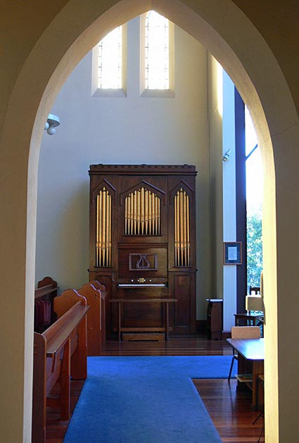 2006 - Moyle Organ, built by James Moyle of Prahran circa 1855 and restored by George Fincham & Sons, Melbourne, in 1985
This organ was built, probably in the 1850s, by James Moyle, of Prahran. It is thought to be the earliest surviving example of organbuilding in Victoria. The original location of the instrument is unknown and its history is vague until its arrival at St Cuthbert's Anglican Church, Brunswick, about 1930. At some stage the pedal pulldowns were added and the hand-blowing arrangements modified. About 1975, the organ was removed from St Cuthbert's Church and stored at Christ Church, Brunswick. The organ was subsequently given to the National Trust of Australia (Victoria) by the Christ Church parish and it was decided to place the instrument, following restoration, at St Linus' Church on permanent loan. 
The restoration of the instrument began in early 1984 following the launching of a restoration appeal by the Prime Minister of Australia, Bob Hawke. The work was carried out by George Fincham & Sons, of Richmond. 
This small instrument, of chamber organ dimensions, has a distinctive Gothic case. There are three flats of gilt wooden dummy pipes placed within three cusped arches. The cornice of-the case is boldly crenellated and the music desk, carved in oak, incorporates a lyre motif. The casework is of pine which has been stained and finished to resemble cedar, although the latter material has been used for the keyboard assembly. The hood moulds above the three cusped arches were at some stage removed and have been replaced. The original builder's nameplate survives.
